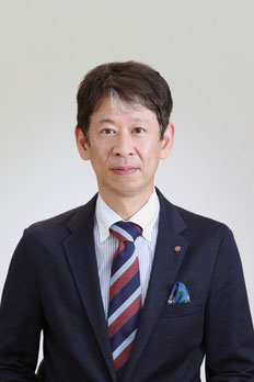 スーツ姿で微笑む、月隈こども園 園長 武内和朋