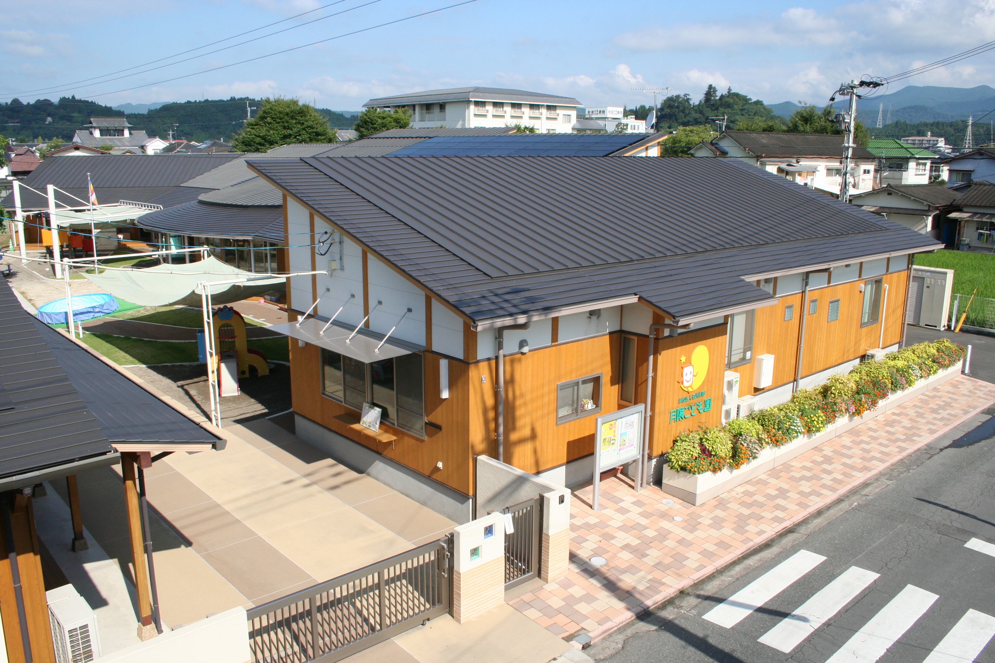 町なみのなかに建つ、木のぬくもりのある園舎の外観