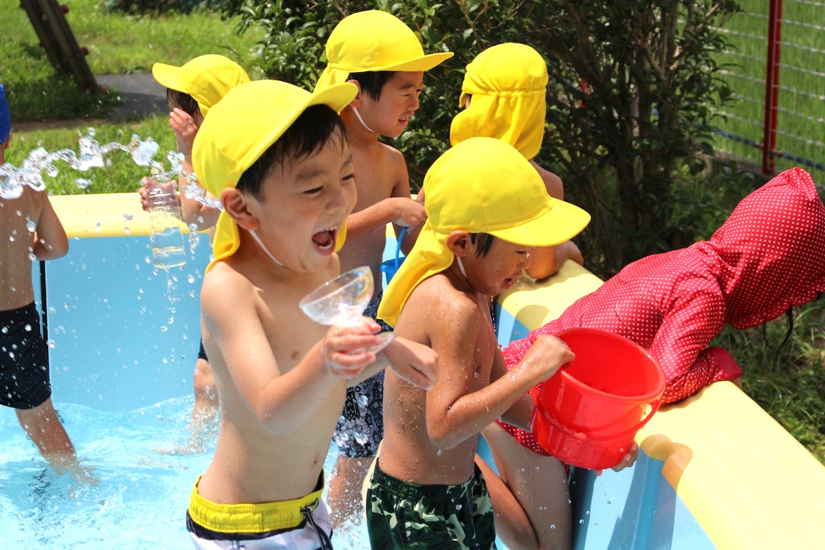 夏のプールで、水しぶきを上げて笑い合う子どもたち