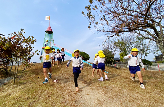 わんぱく山の斜面を、声をあげてかけおりる子どもたち
